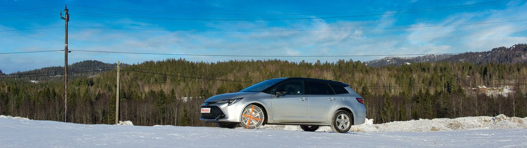 Banner image showing passenger car in beautiful winter nature, standing on a hill with AutoSock installed